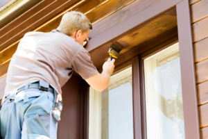 a man painting his home’s exterior